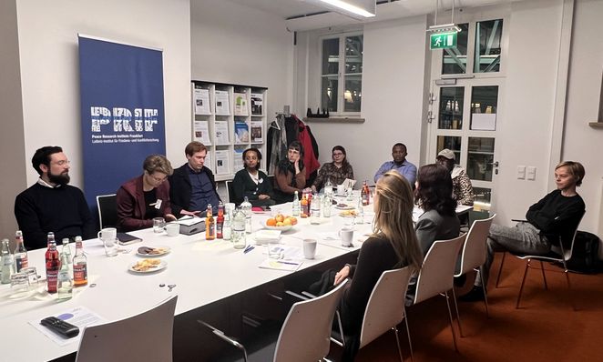 PhD Workshop of the Leibniz Research Network CrisEn Researchers and doctoral students sit around a meeting table and listen to an introduction to career development at the Leibniz Association.